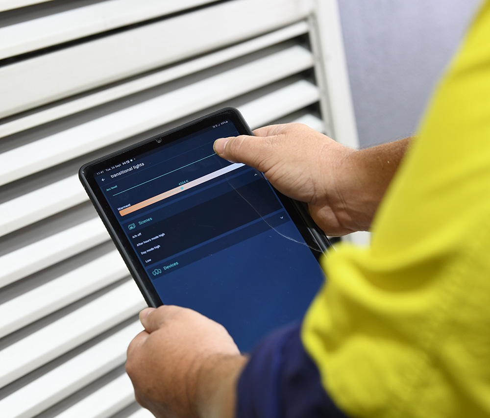 Worker in high vis with tablet controlling DALI lighting